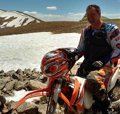 Alpine Tree Service team member on a dirt bike